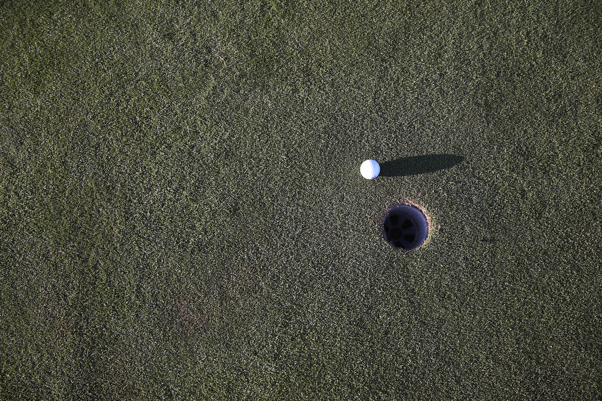 Golf ball near hole on golf course